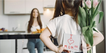 niña regalando flores a mamá por su día